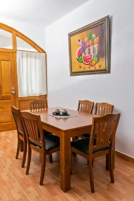 a dining room table and chairs with a picture on the wall at Villa Zapata - Apartamentos Turísticos in San Cristóbal