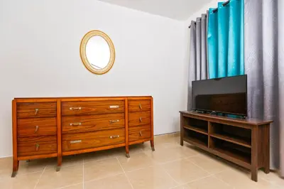a bedroom with a dresser and a tv and a mirror at Villa Zapata - Apartamentos Turísticos in San Cristóbal