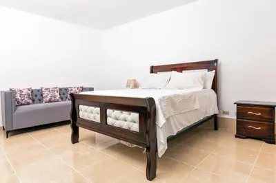 a bedroom with a bed and a couch at Villa Zapata - Apartamentos Turísticos in San Cristóbal