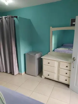 a bedroom with a bed and a dresser and a mirror at Central Rooms Bayahibe in Bayahibe