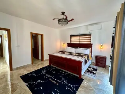 a bedroom with a bed and a chandelier at Villa Selina in Punta Cana