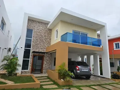 a house with a car parked in front of it at Villa Selina in Punta Cana