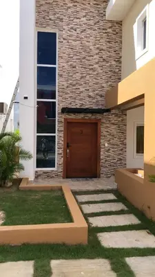 a house with a wooden door and a brick wall at Villa Selina in Punta Cana