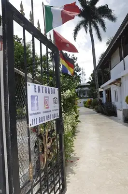 a gate with a sign on a fence with flags at Hotel Piedra Marron in Las Terrenas