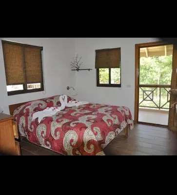 a bedroom with a bed with a red and white blanket at Hotel Piedra Marron in Las Terrenas