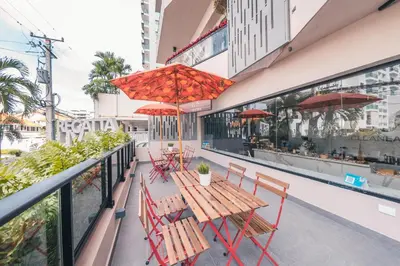 a table and chairs on a balcony with red umbrellas at Breakfast Included at Regatta Living 802 in Los Prados