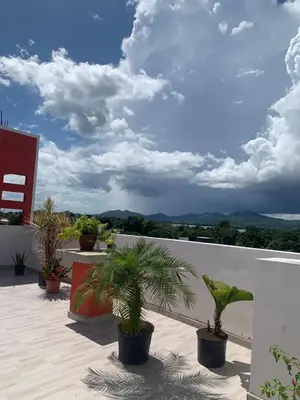 a balcony with potted plants and a cloudy sky at Plataview Apartahotel apt 4C in Monte Plata