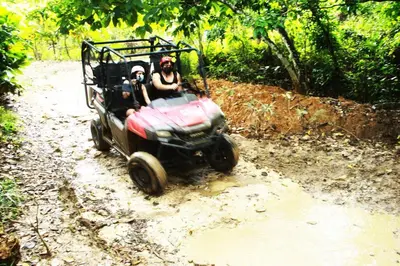 two people riding a toy car on a dirt road at Apartamento de 2 Dormitorios en Hard Rock Golf in Punta Cana