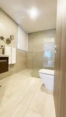 a bathroom with a toilet and a glass shower at Apartamento de 2 Dormitorios en Hard Rock Golf in Punta Cana
