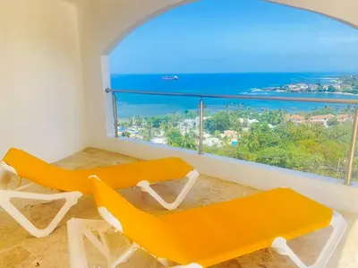 a room with two orange chairs and a large window at Heavenly View in San Felipe de Puerto Plata