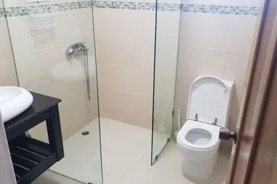 a bathroom with a toilet and a glass shower at Heavenly View in San Felipe de Puerto Plata