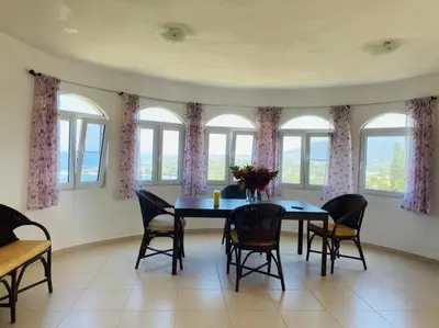 a dining room with a table and chairs and windows at Heavenly View in San Felipe de Puerto Plata