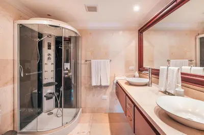 a bathroom with two sinks and a shower at Seaside Bliss with pool and spectacular view in Las Minas
