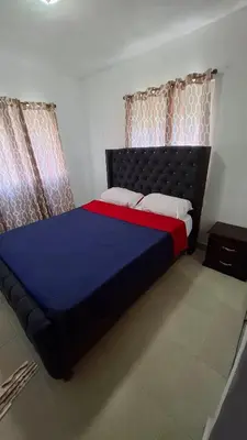 a bedroom with a large bed with blue and red sheets at Apartamento acogedor J-A in Los Paredones