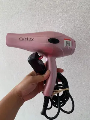 a person holding a pink hair dryer with a phone at Plataview Apartahotel apt 3C in Monte Plata