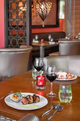 a table with two plates of food and glasses of wine at Royalton CHIC Punta Cana, An Autograph Collection All-Inclusive Resort & Casino, Adults Only in Punta Cana