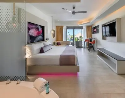 a hotel room with a bed and a bathroom at Royalton CHIC Punta Cana, An Autograph Collection All-Inclusive Resort & Casino, Adults Only in Punta Cana