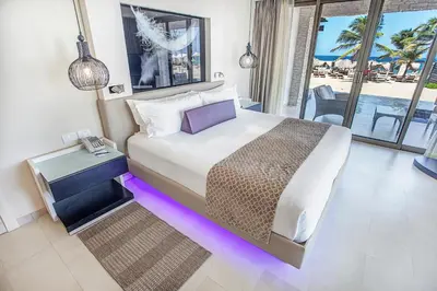 a bedroom with a large bed with purple lighting at Royalton CHIC Punta Cana, An Autograph Collection All-Inclusive Resort & Casino, Adults Only in Punta Cana