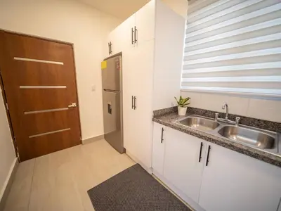 a small kitchen with a sink and a door at Luxurious Listed New Villa With 5 Br- 6 Bt In Sosua in Sosúa