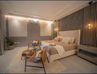 a bedroom with a large bed and two chairs at Luxurious Listed New Villa With 5 Br- 6 Bt In Sosua in Sosúa