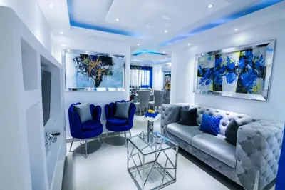 a living room with a couch and blue chairs at Breezes by TECASA in Santiago de los Caballeros