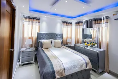 a bedroom with a large bed and a mirror at Breezes by TECASA in Santiago de los Caballeros