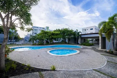 a swimming pool in front of a building at Breezes by TECASA in Santiago de los Caballeros