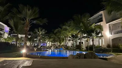 a swimming pool at night with palm trees and buildings at Estrella Dominicus Ekskluzywny Apartament ,,Bajeczny Widok,, in La Laguna