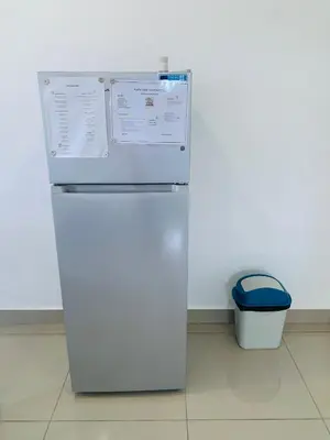 a white refrigerator in a kitchen with a trash can at Plataview Apartahotel apt 4A in Monte Plata