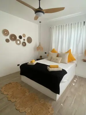 a bedroom with a large bed and a ceiling fan at Portitxol, fantástico apartamento in Bayahibe
