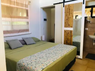 a bedroom with a bed with a window and a sink at Sfeervolle studio in Encuentro Cabarete in Cabarete