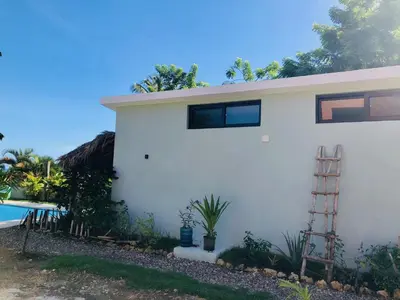 a white house with a ladder next to a pool at Sfeervolle studio in Encuentro Cabarete in Cabarete