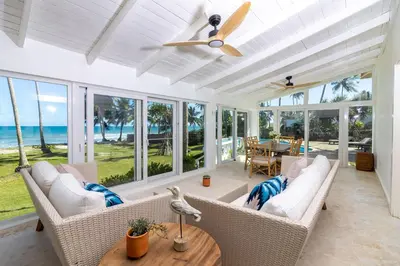 a living room with white furniture and a ceiling fan at Las Canas Beach Retreat in Gaspar Hernández