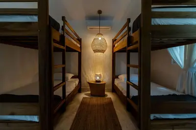 a room with three bunk beds and a lamp at Las Canas Beach Retreat in Gaspar Hernández