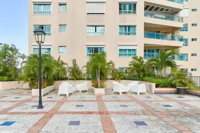 a row of white chairs in front of a building at Luxurious 2BDR with Ocean View in Santo Domingo