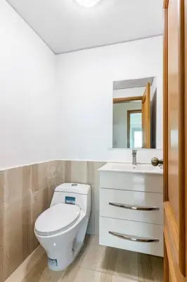 a bathroom with a white toilet and a sink at Luxurious 2BDR with Ocean View in Santo Domingo