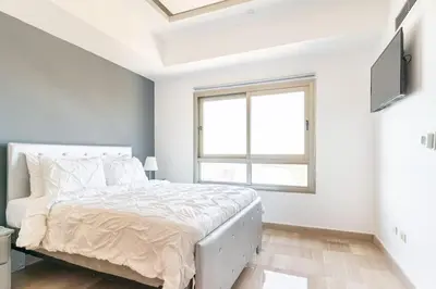 a white bedroom with a bed and a window at Luxurious 2BDR with Ocean View in Santo Domingo