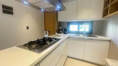 a white kitchen with a stove and a sink at Tropical Relaxing 2 Bedroom Unit with picuzzi in Punta Cana