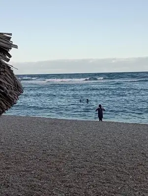 a person standing on a beach near the ocean at Agradable Apartamento in Paraíso