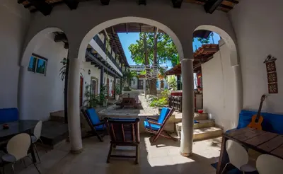 a patio with chairs and tables in a building at Island Life Hostel in Santo Domingo