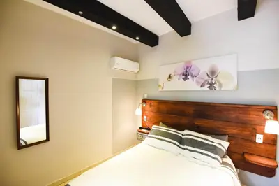 a bedroom with a wooden headboard and a mirror at Island Life Hostel in Santo Domingo