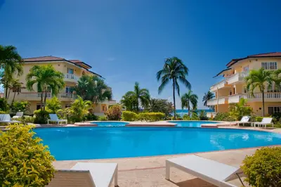 a swimming pool in front of a building at Las Palmeras by Graziano in Boca Chica