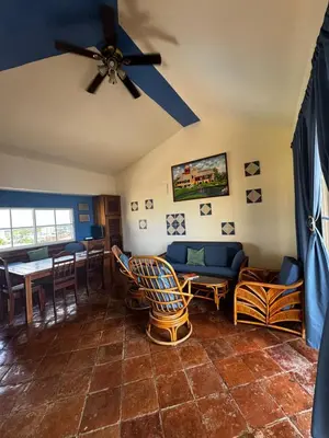 a living room with a ceiling fan and a table at Las Palmeras by Graziano in Boca Chica