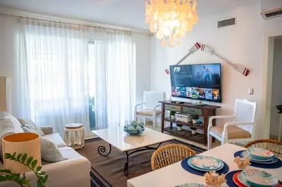 a living room with a couch and a tv at Riviera Azul -2 Hab con vista a la Piscina - cash only or paypal in San Felipe de Puerto Plata