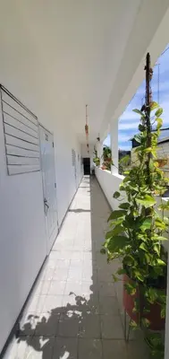 a hallway with potted plants in a white building at Tus Recuerdos in Santo Domingo