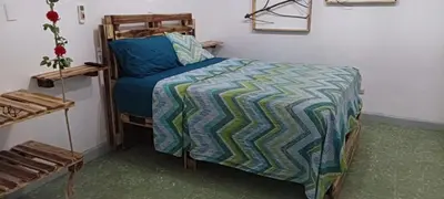 a bedroom with a bed with a blue and green comforter at Tus Recuerdos in Santo Domingo