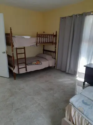 a bedroom with two bunk beds and a tiled floor at Marmota House in Santa Bárbara de Samaná