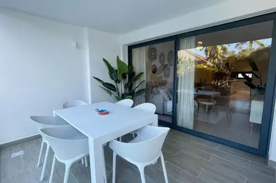 a white dining room with a white table and chairs at Tropical Deluxe 2 Bedroom Unit with Picuzzi in Punta Cana