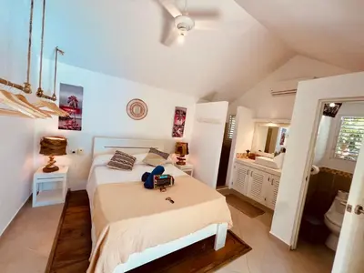 a white bedroom with a bed and a bathroom at Villa Clarissa No. 8 in Las Terrenas