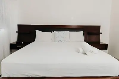 a large white bed with white sheets and pillows at Oceanfront 3 Bedroom With Jacuzzi and Pool in Santo Domingo